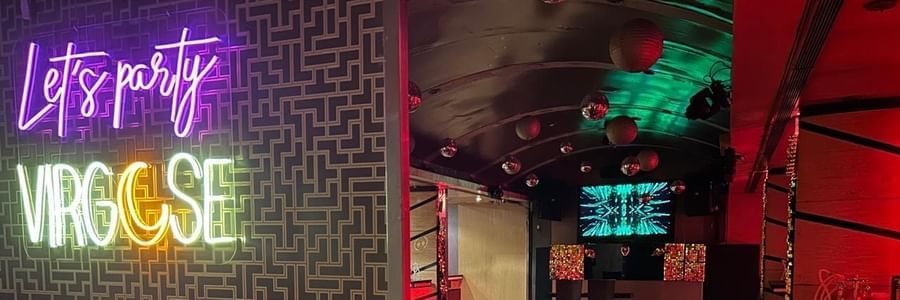 Seating area with Virgose neon sign and warm lighting at Hotel Hindusthan International, Kolkata