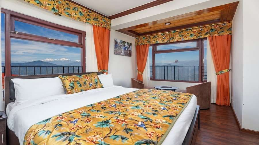 Image of a room with two large windows and a bed at Summit Sherpa Mountain Hotel & Spa, Kalimpong