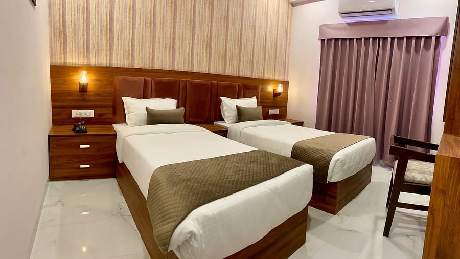 Room with twin beds and wooden headboard  at Hotel Mumbai House, Indore