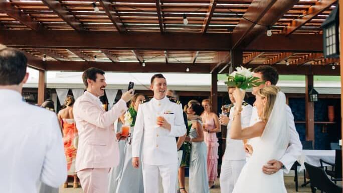 Bride and groom walk down the aisle under a wood pavilion, surrounded by guests at Abaco Inn.