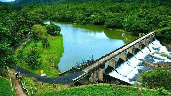 Aerial view of the dam surrounded by trees and mountains