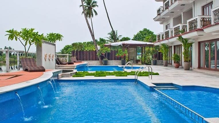 swimming pool with palm trees at White Pearl Resort by Rosetum