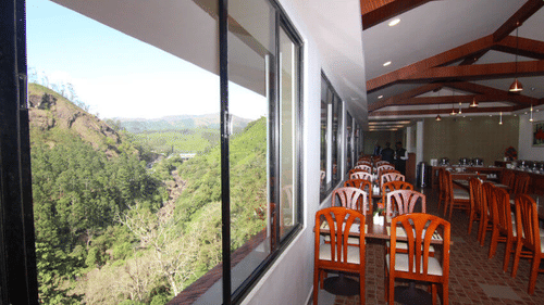 Abad Copper Castle restaurant interior with a scenic view through large windows.
