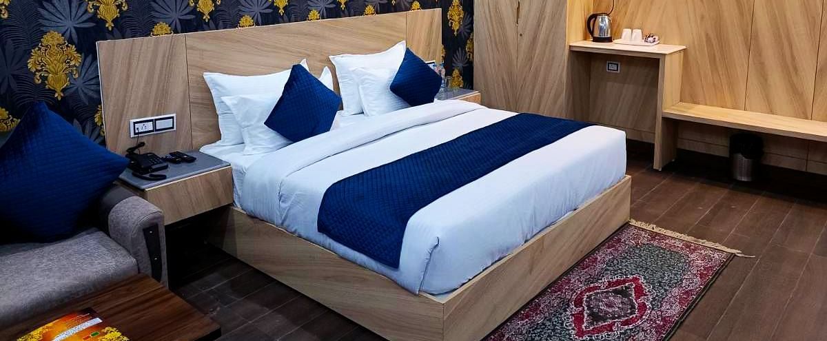 A Deluxe Room at DLS Nature Trinket Resort with a king size bed and a side table.