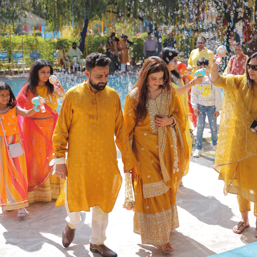 Couple walking during a vibrant haldi ceremony celebration at Umaid Palace.