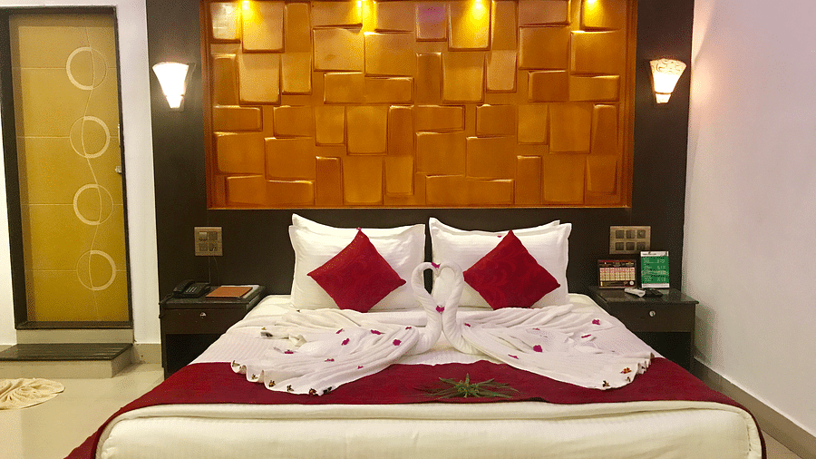 Image of a bed decorated with flower petals and towels at Coorg Jungle Camp Backwater Resort, Kushalnagar.