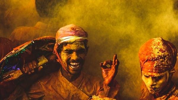 People enjoying  with coloured powder.
