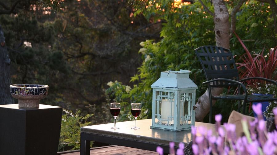 A deck with lanterns and comfy chairs amid greenery - Brewery Gulch Inn & Spa