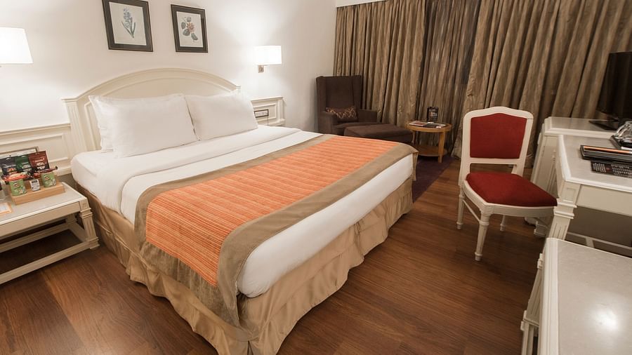 room with king size bed and wooden flooring at hotel bawa international