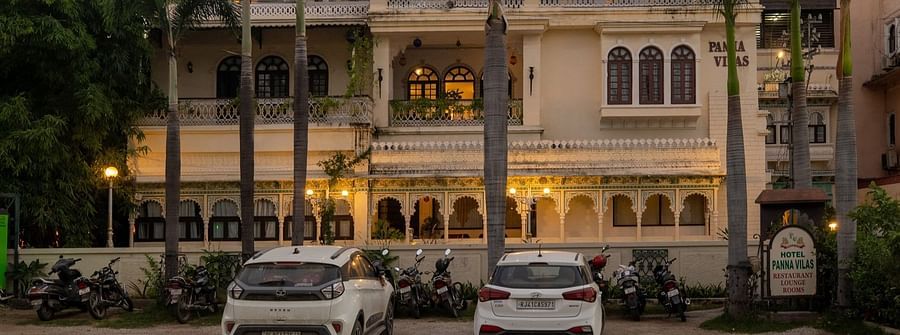 A facade view of Panna Vilas Palace, featuring cars parked infront the building| Panna Vilas Udaipur | Panna Vilas Udaipur