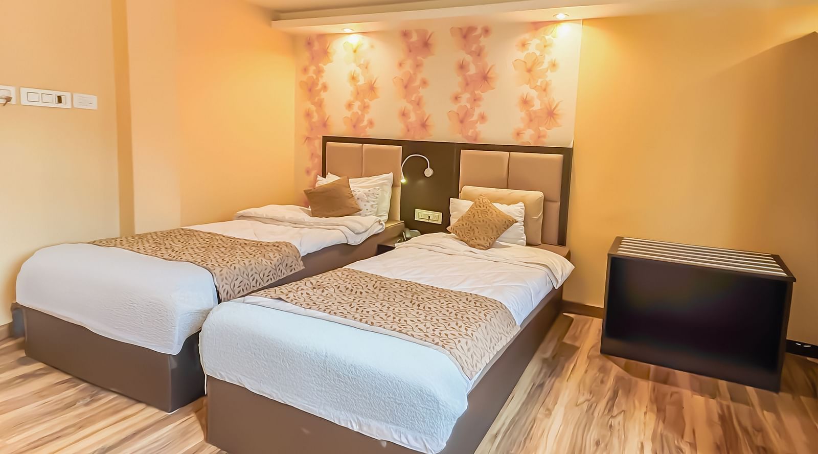 Twin beds with a decorative painting behind the headboard at Avianna Hungry Jack, Gangtok.