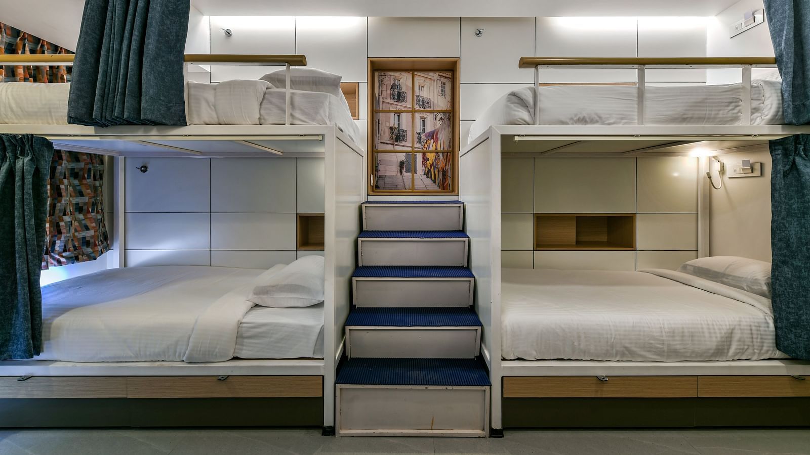 An image of dormitory room featuring beds on upper and lower berths and there is a flight of stairs leading to beds on top - Indie Stays, Chembur.