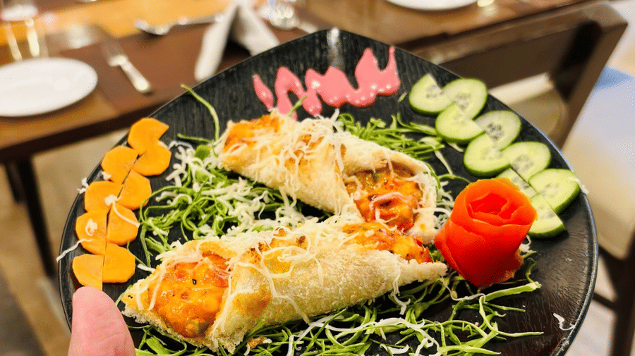 A serving of 2 fried chicken pockets served with fresh greens along with sliced cucumber and carrot at Navidya Restaurant - Amantra Comfort Hotel