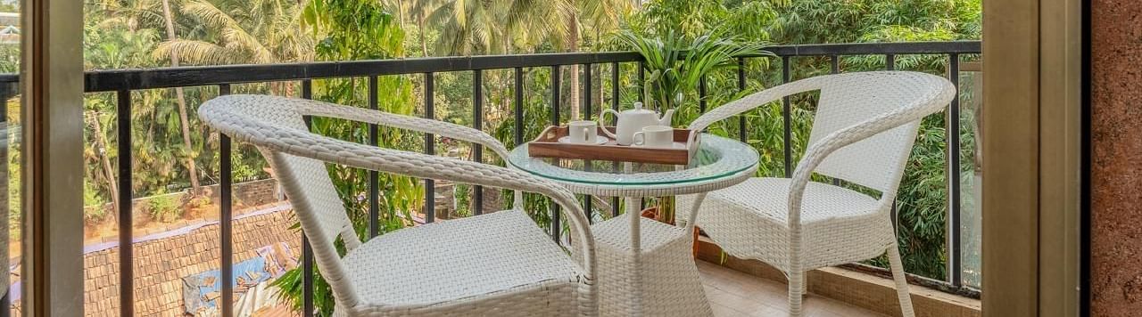 Image of the balcony at Grand Room with two chairs and a table at Calux Joia Do Mar Resort, Goa.