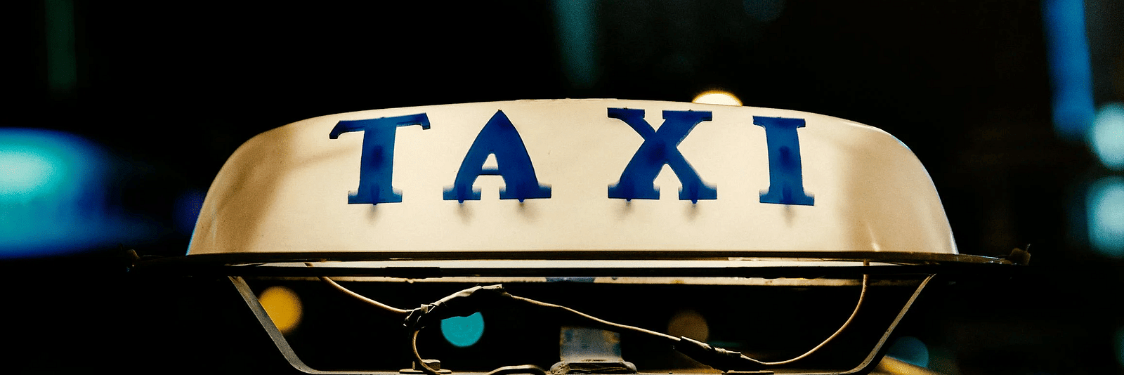 An illuminated sign featuring the word 'taxi' displayed prominently.