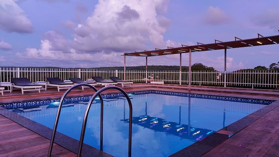 Swimming pool with staricase leading to the pool  at Vagator Downtown, Goa