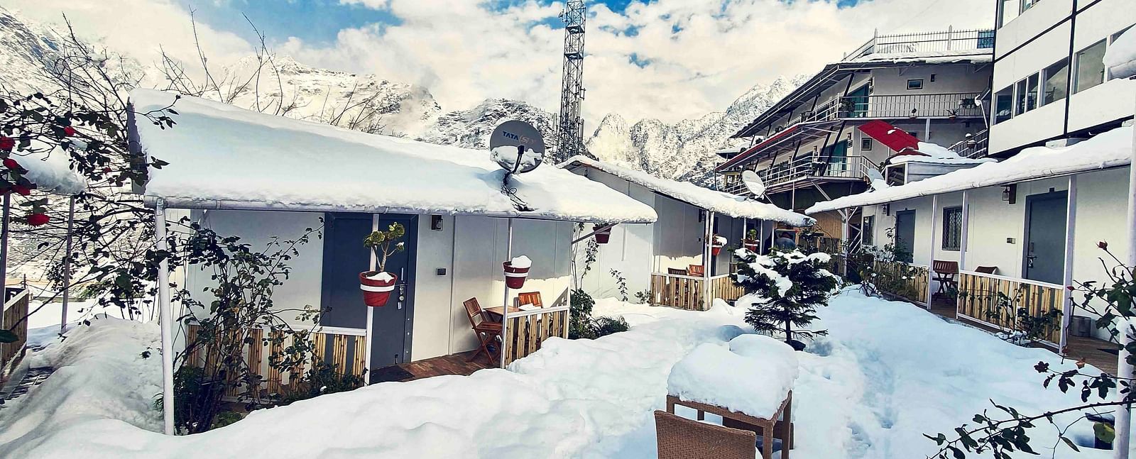 facade image of the Tattva Boutique Resort in joshimath with a think cover of white snow all over the place