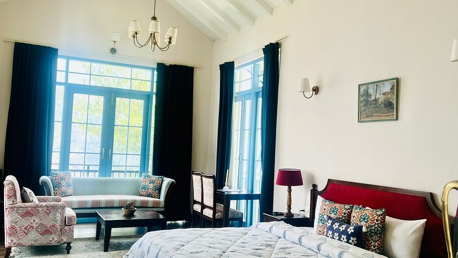 Elegant hotel room with large bed, dark blue curtains, and sunlit windows | Faraway Cottages, Auli
