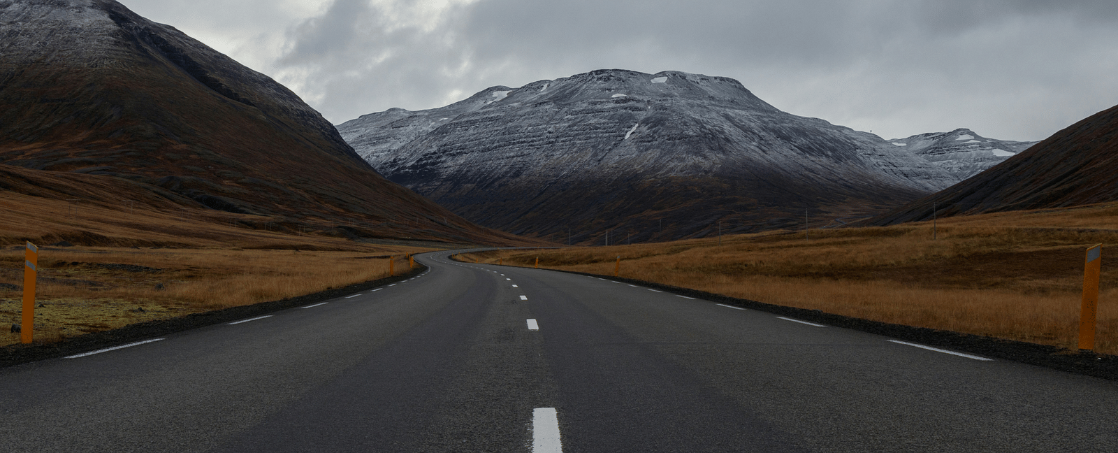 An overview of a highway with single lanes on either side and a mountain in the background.