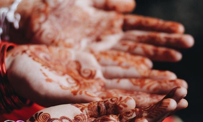 A close up shot of two henna stained hands