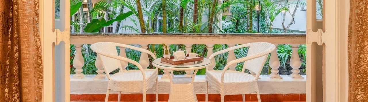 Image of the balcony at Junior Suite with two chairs and a table at Calux Joia Do Mar Resort, Goa.