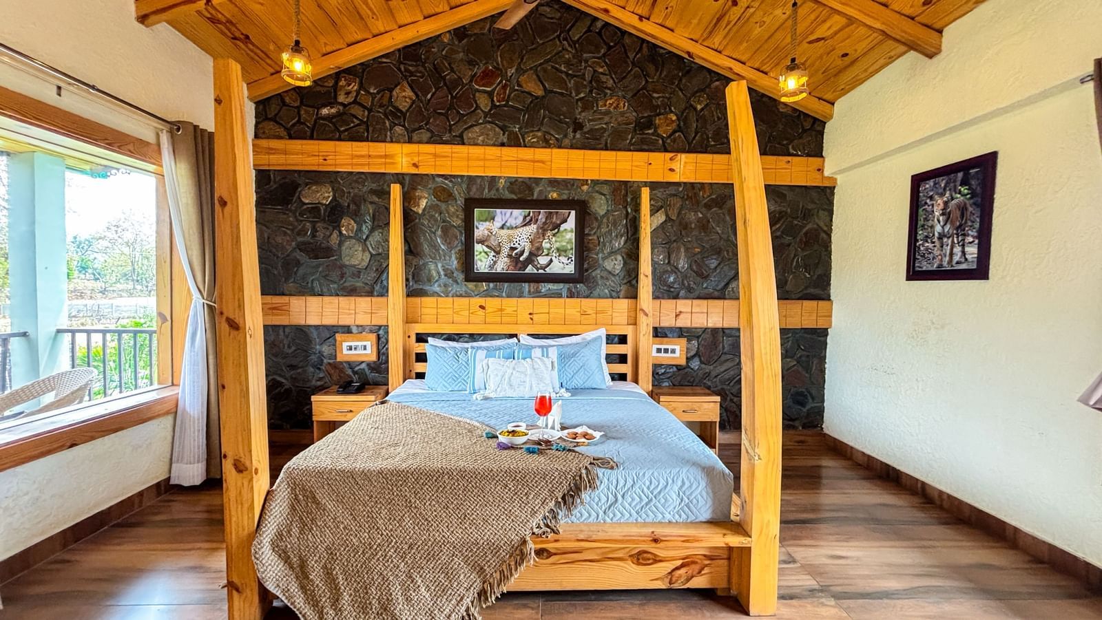 Elegant bedroom with four-poster bed and rustic decor at Corbett Nirvana Resort.