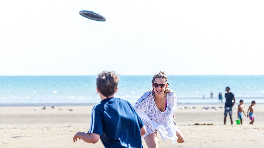 People playing frisbee on the beach