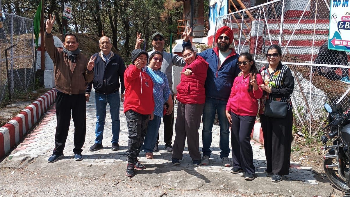 Group of people posing for a photo outside a restaurant named 'Tip N Top' in Lansdowne during daytime.