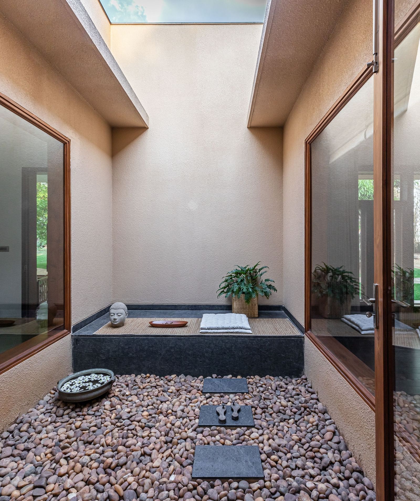 Bathroom with a dark bathtub, stone pebbles, skylight, natural light, modern design - Shreyas Retreat