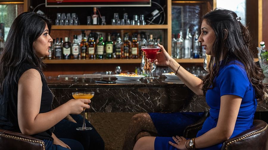 Two people enjoying the drinks in the bar at Golden Suites, Gurgaon