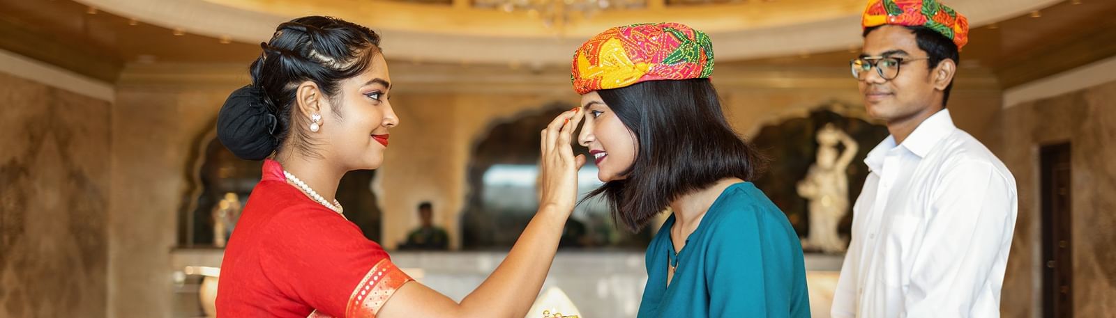 A woman dressed in red welcoming our guests in the traditional Rajasthani way - Kaldan Samudhra Palace, Mahabalipuram
