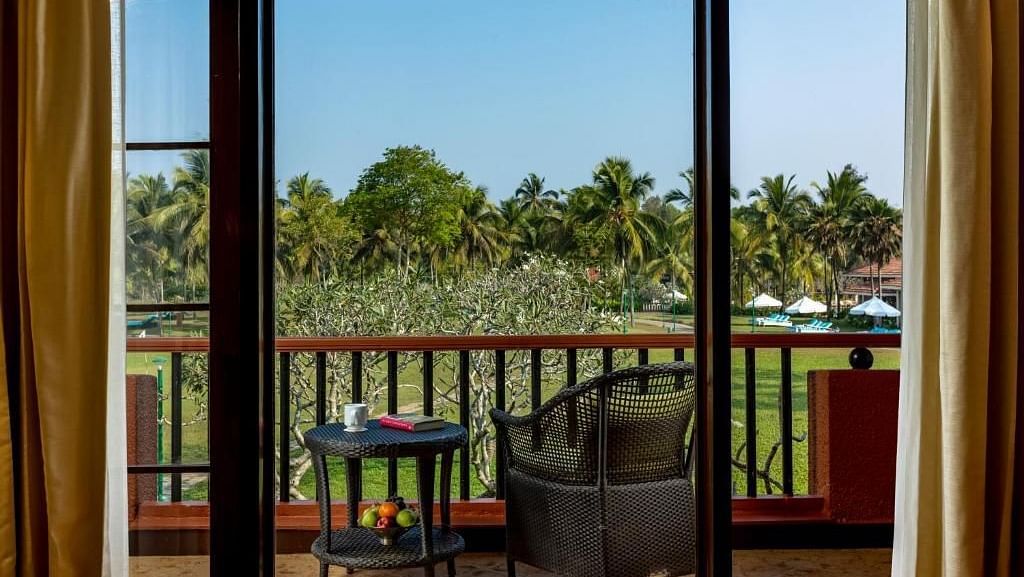 two chairs and a table in the balcony of a room - Caravela Beach Resort Goa