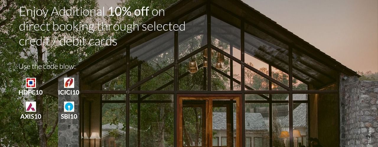 Glass-front resort at sunset, offering extra 10% off with select bank cards and promo codes.