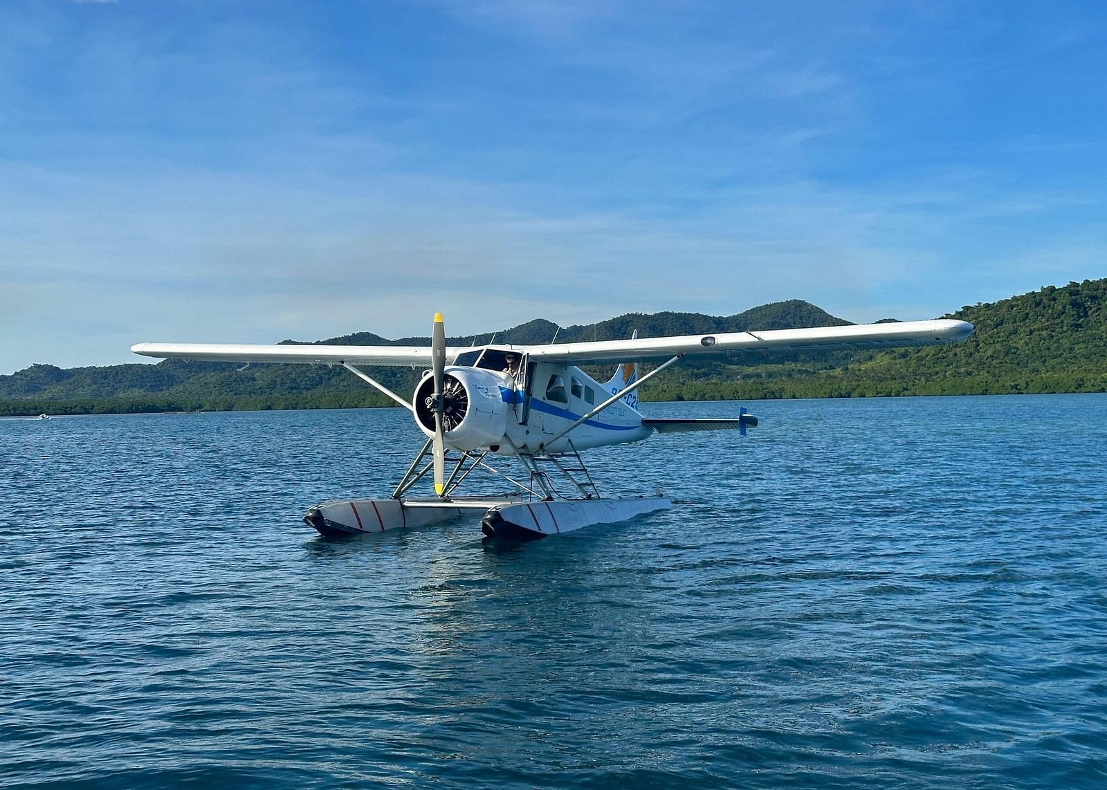 Seaplane floating on calm blue sea near Flower Island Resort.