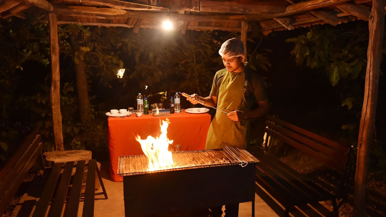 An intimate dining experience at Forest Escapes Koyna, with a softly lit table set for two in a rustic setting.