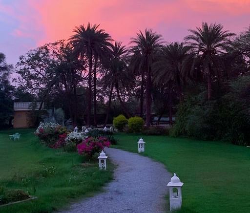 image of the Garden area along with a stone pavement in the middle at Dev Shree during sunset