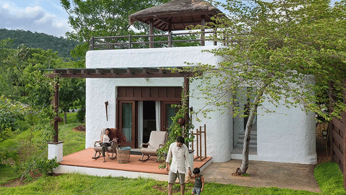 Facade of The Residence with a man and a child in front of the building at The Serai Bandipur