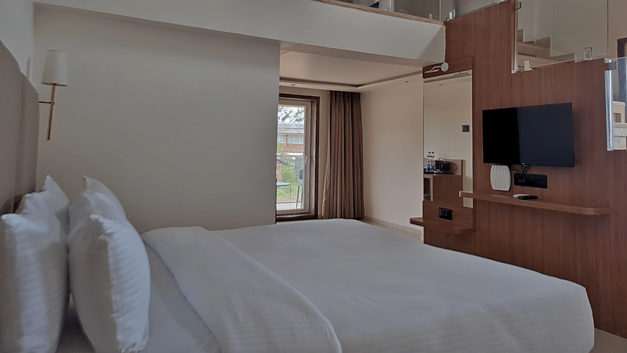 Bedroom with a double bed, television, wooden furnishings, and loft area