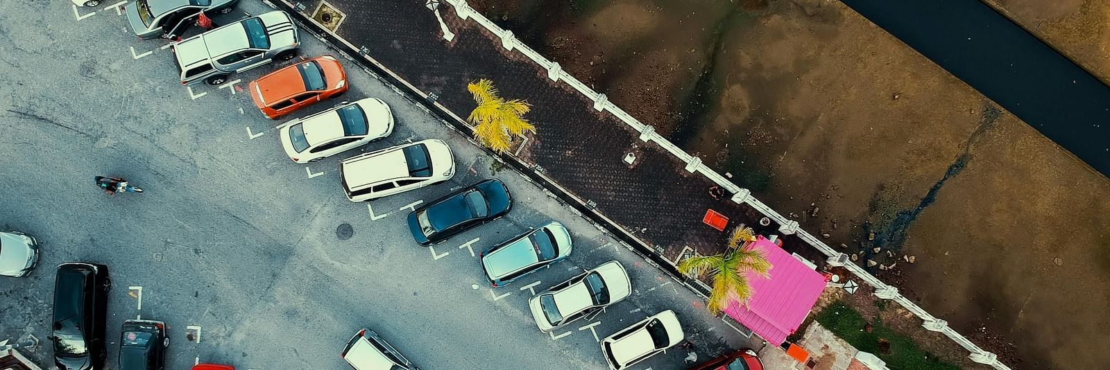 An aerial view of a parking lot with cars parked beside each other.
