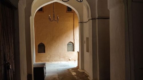 A carpeted walkway leading to a room with natural lighting.