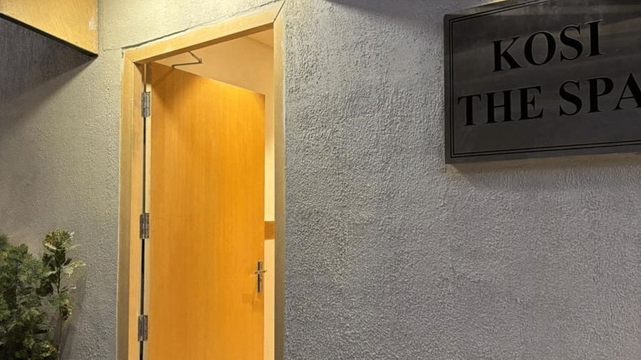 Entrance of the spa room at ABN Sarovar Portico, Jim Corbett featuring a nameplate which says, Koshi The Spa and next to it there is a door leading to the spa room.