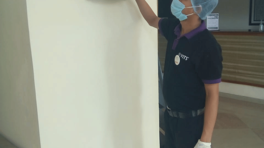 a staff member cleaning a picture at one of the hotels - VITS Hotels & Resorts