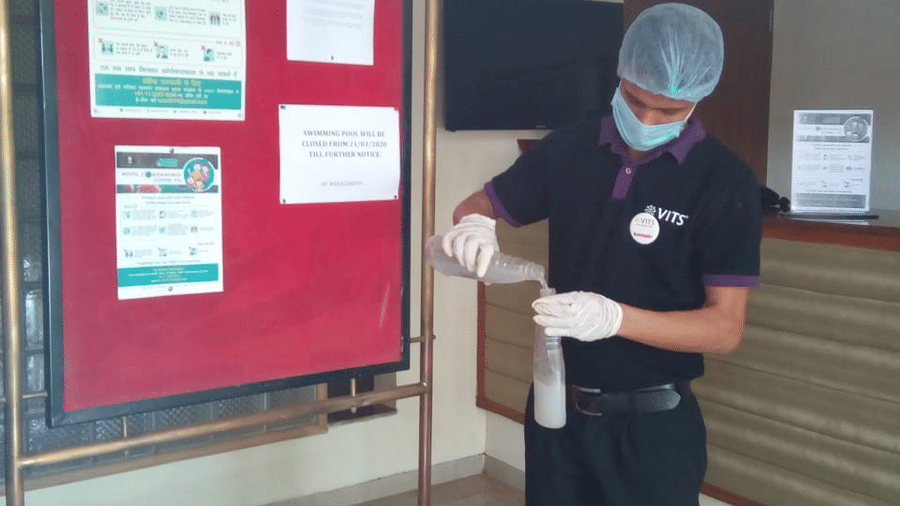 a staff member cleaning the notice board at one of the hotels - VITS Hotels & Resorts