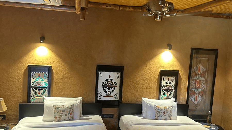 A well-appointed bedroom with two single beds and traditional decor at Aamaghati Wildlife Resort.
