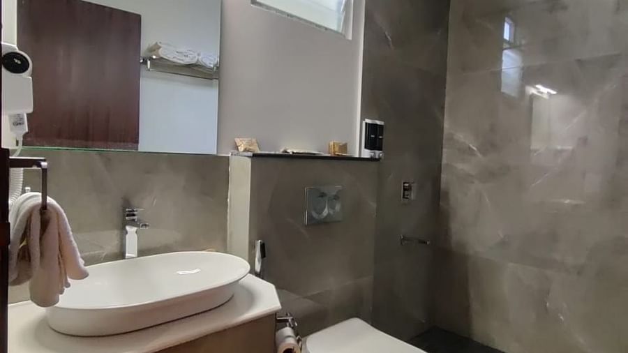 Contemporary bathroom with a sleek sink, large mirror, and modern fixtures - Arina Island Resort, Swaraj Dweep