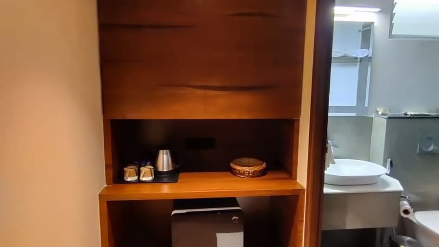Compact area with wooden shelving and a minibar, leading to the bathroom - Arina Island Resort, Swaraj Dweep