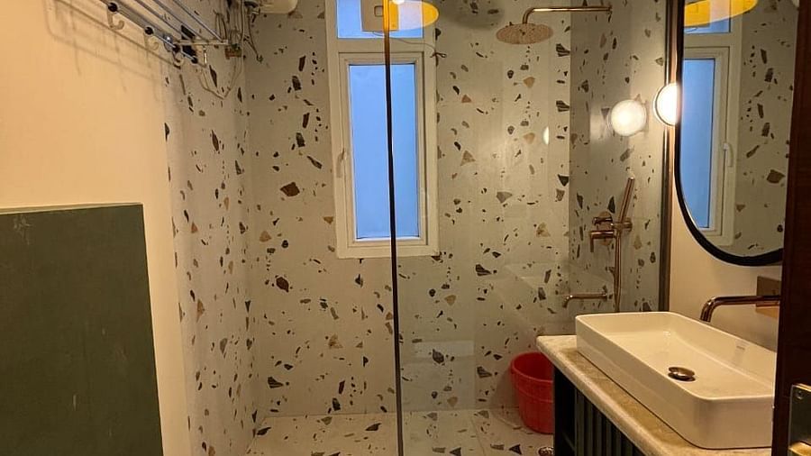 A modern bathroom with a shower, washbasin, and a yellow light fixture - Asian Suites IFFCO Metro, Gurgaon