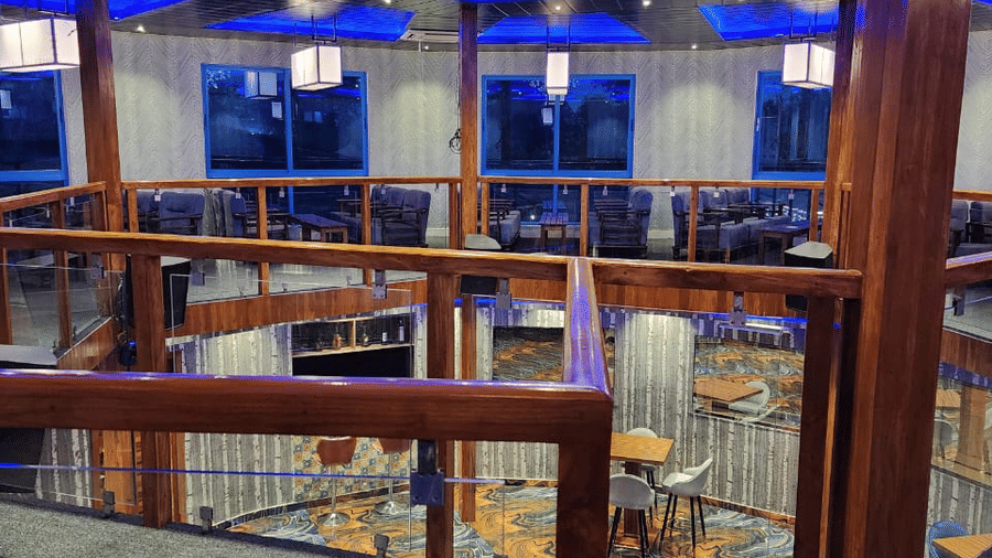 Multi-level event hall with a large chandelier and vibrant blue neon lighting - DAN Resorts & Weddings, Palghar