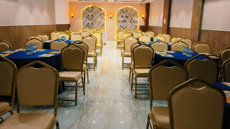Banquet hall at Hotel Mumbai House, Vashi with arranged seating and warm lighting suitable for meetings or events.