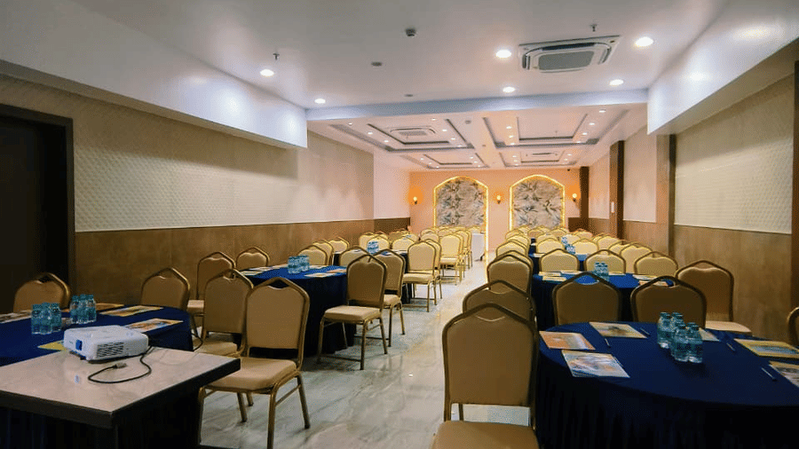 Banquet setup at Hotel Mumbai House, Vashi showing rows of chairs and tables arranged for a gathering or meeting.